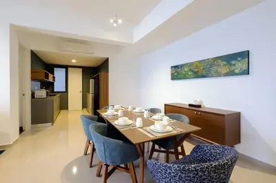 a dining room with a table and blue chairs at Seaview Studio 2BR 3BR Tanjung Point Residences in Tanjong Tokong