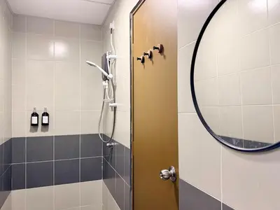 a bathroom with a shower with a round mirror at Asa and Mori Japandi, Emerald Avenue, Brinchang in Tanah Rata