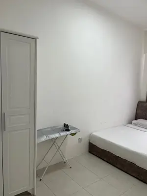 a white bedroom with a bed and a table at The White Mist Cameron in Tanah Rata