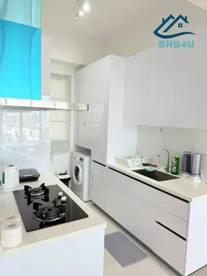 a white kitchen with a stove and a sink at Beacon 2 bedroom at Jalan Sungai Pinang George Town Penang in George Town