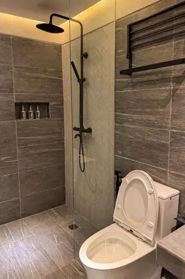 a bathroom with a toilet and a shower with a glass door at Playce Hotel in George Town