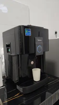a coffee machine with a cup on a counter at Sofea Stay Homestay Sungai Petani in Sungai Petani