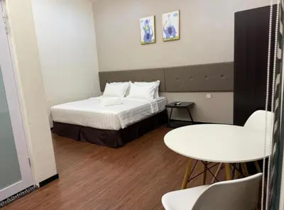 a small room with a bed and a table at King's Lane in Ipoh