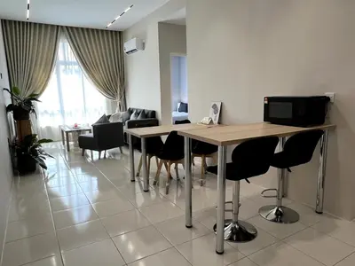 a room with a table and chairs and a living room at Relaxstay Anderson Residences, Family Friendly 6px 2br in Ipoh