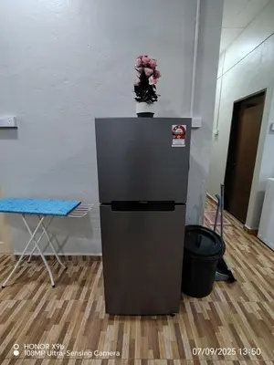 a refrigerator with a vase of flowers on top of it at Homestay Haji Omar Sungai Dua Butterworth in Kampong Lahar Yooi