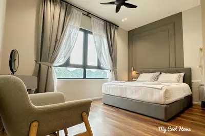 a bedroom with a bed and a chair and a window at Onsen Suite Theme Park View in Ipoh