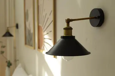 a black lamp hanging on the side of a wall at Sarang A Cottage with private pool in Sungai Petani