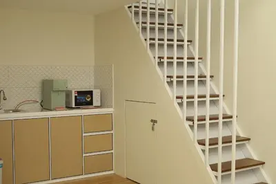 a kitchen with a staircase leading up to a room at Sarang A Cottage with private pool in Sungai Petani