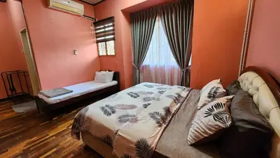 a bedroom with orange walls and a bed and a window at Afnaz Homestay Penang in Perai