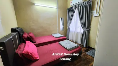 a small room with two beds and a window at Afnaz Homestay Penang in Perai