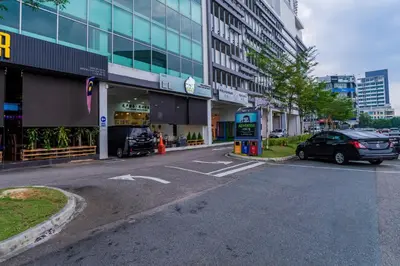 a car parked in a parking lot in front of a building at Austin Manhattan by RR JBcity in Gua Sai