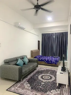 a living room with a couch and a bed at Mekla Hotel Studio Apartment in Gua Musang