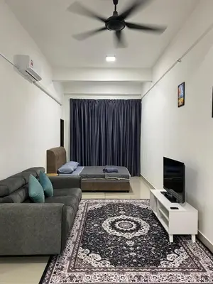 a living room with a couch and a ceiling fan at Mekla Hotel Studio Apartment in Gua Musang