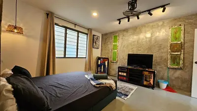 a bedroom with a bed and a flat screen tv at Batu Puteh Chalet by the River, Pool, WIFI