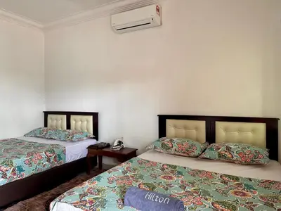 a bedroom with two beds and a phone on a table at Villa Desa Permai in Sungai Besar