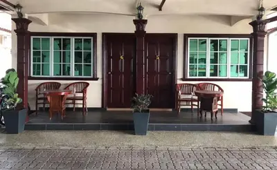 a group of chairs and tables on a porch at Villa Desa Permai in Sungai Besar