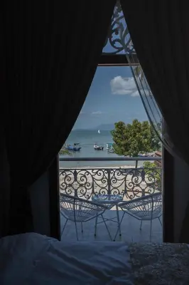 a bedroom with a view of the ocean from a balcony at Coconut Bay beach Villa seaview karaoke 20pax in Tanjung Bungah