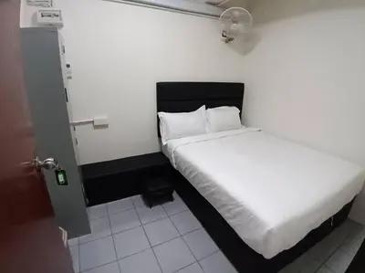a bedroom with a white bed in a room at Sun Hotel Penang in George Town