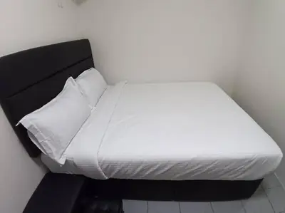 a bed with white sheets and pillows in a room at Sun Hotel Penang in George Town