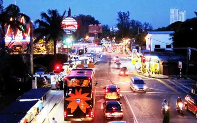 a busy city street with cars and a double decker bus at Batu Ferringhi Sri Sayang Resort in Batu Ferringhi