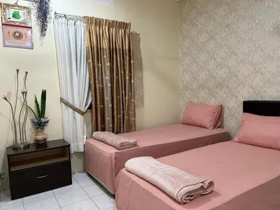 a room with two beds and a window at Taman Gerik Homestay in Gerik