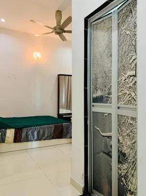 a bedroom with a bed and a sliding glass door at Taiping Nest Homestay 3BR, 7Pax, WiFi, Private Parking, Comfy in Taiping