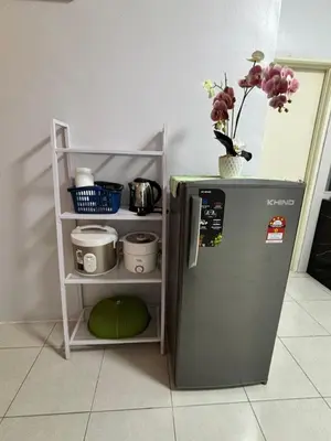 a small refrigerator next to a shelf with flowers on it at HS Homestay Casa Klebang Ipoh in Chemor