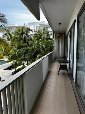 a balcony with a bench and palm trees at Azure Haven - Seaview Resort Home, By the Sea Batu Ferringhi in Batu Ferringhi