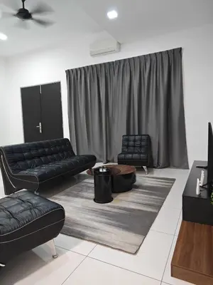 a living room with two black couches and a table at Cozy Haven \u6696\u5fc3\u5c45 in Simpang Ampat