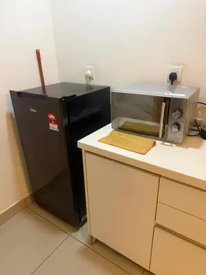 a kitchen with a black refrigerator and a microwave at Studio Unit Trefoil Setia Alam in Gua Sai