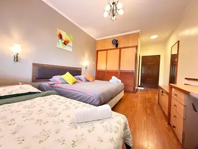 a bedroom with two beds and a dresser at Equatorial Hill Resort, Mountain view In Cameron Highlands in Brinchang