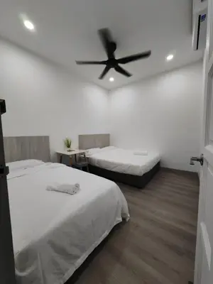 a bedroom with two beds and a ceiling fan at I-homey Residence 1 in Gua Sai