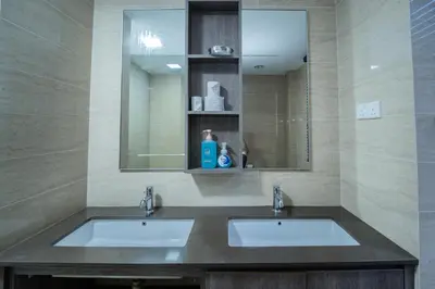a bathroom with two sinks and a mirror at By The Sea Haven 2BR 6pax in Batu Ferringhi