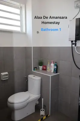 a bathroom with a white toilet and a window at Alaa De Amansara Homestay in Kepala Batas