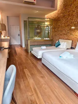 a bedroom with two beds and a brick wall at Loke Thye Kee Heritage Hotel in George Town