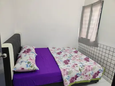 a small bedroom with a purple bed with two pillows at Margosa Homestay in Ipoh