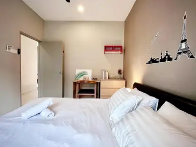 a bedroom with a white bed and a desk at Charming 4BR Family House Quite Area & Cozy in Simpang Ampat