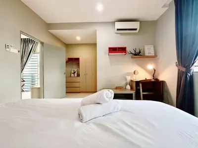 a bedroom with a white bed with towels on it at Charming 4BR Family House Quite Area & Cozy in Simpang Ampat