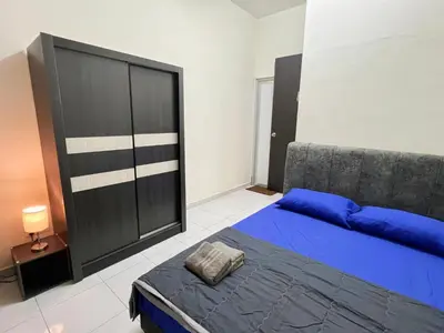 a bedroom with a blue bed and a couch at Homestay Sungai Petani 3 Bedroom in Taman Mutiara Bandar Puteri Jaya by D'Aleena Homes in Sungai Petani