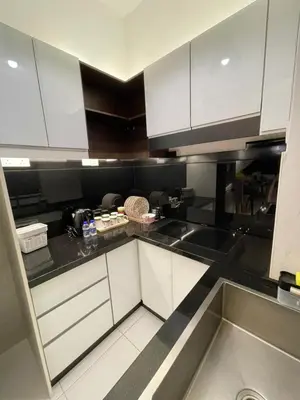 a kitchen with white cabinets and black counter tops at Oasis Condominium Ipoh in Ipoh