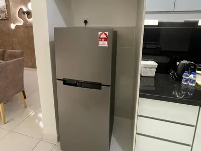 a silver refrigerator in a kitchen with a counter at Oasis Condominium Ipoh in Ipoh