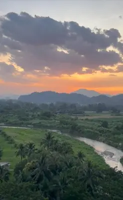 a view of a river and palm trees at sunset at Oasis Condominium Ipoh in Ipoh