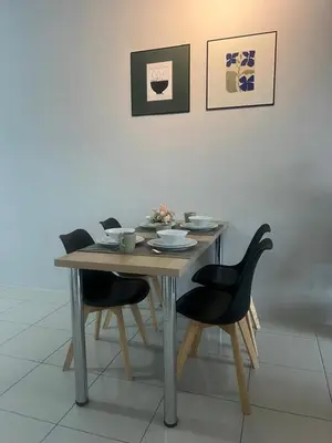 a wooden table with four chairs and a table with dishes on it at Ipoh Modern Skyline & Mountain View Suite in Ipoh