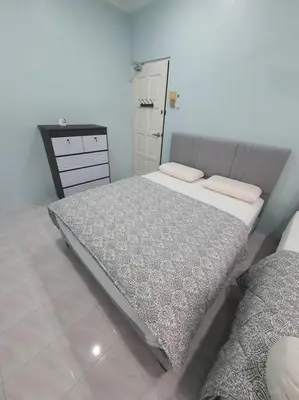 a bedroom with two twin beds and a dresser at Lumut Homestay for Muslims in Lumut