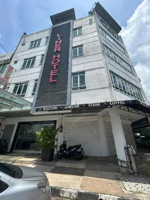 a building with a motorcycle parked in front of it at Liner hotel in Simpang