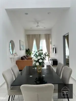 a dining room table with white chairs and a vase of flowers at Zafirah Ipoh Homestay Musllim Only in Ipoh
