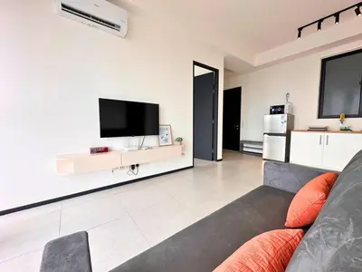 a living room with a couch and a flat screen tv at Urban Seaview, City view, New 3BR 6pax, Jelutong in George Town