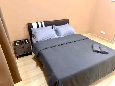 a bedroom with a large bed and a night stand at HOMESTAY Mu in Simpang Ampat