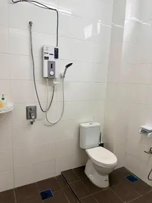 a bathroom with a toilet and a shower at HOMESTAY Mu in Simpang Ampat