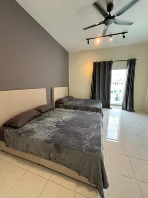 a bedroom with two beds and a ceiling fan at pangkor 71 homestay in Pasir Bogak